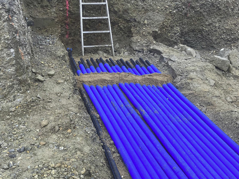 Grube mit einer Leiter und blauen Rohren